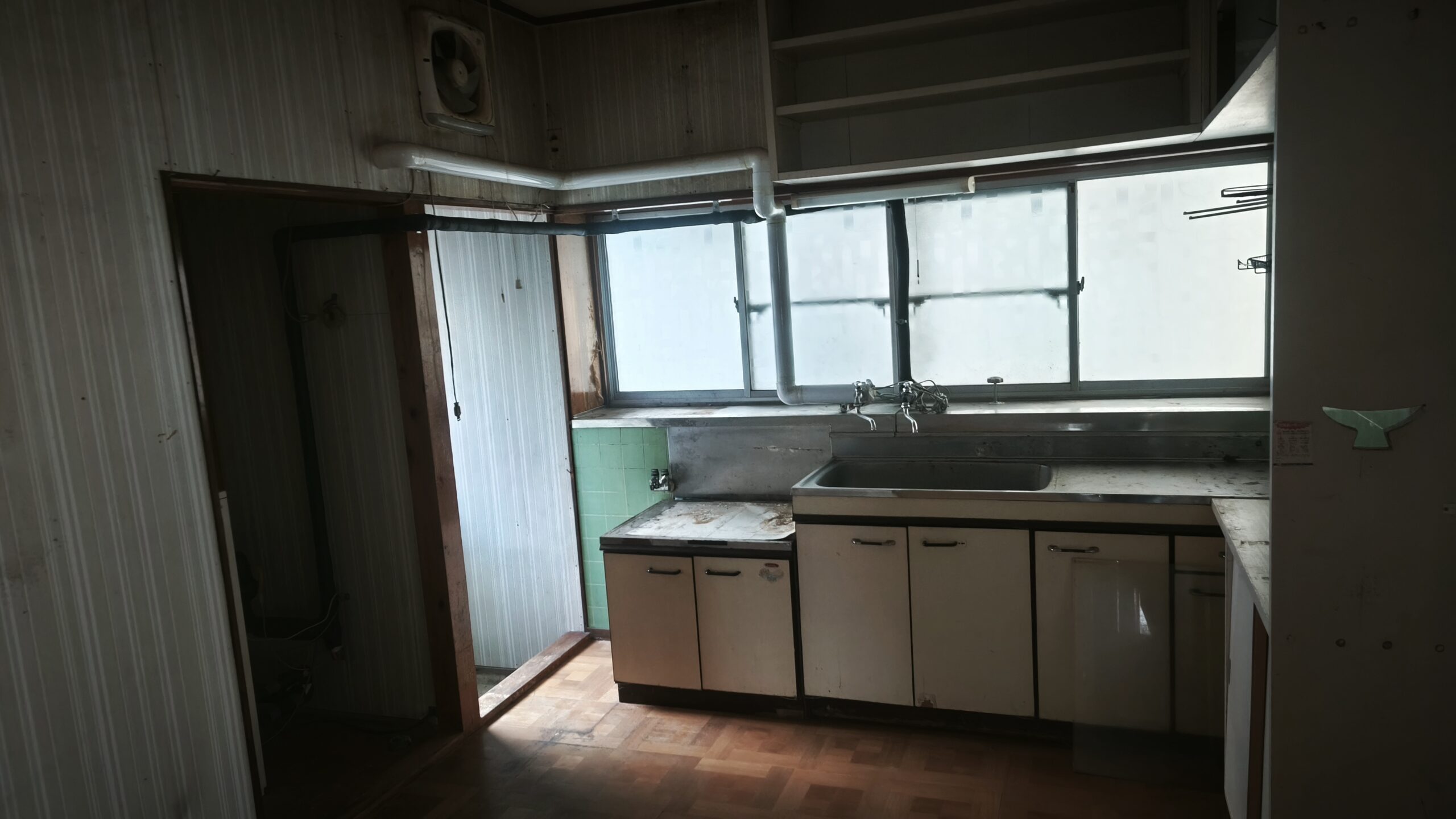実家の台所。古い流し台と傷んだ床